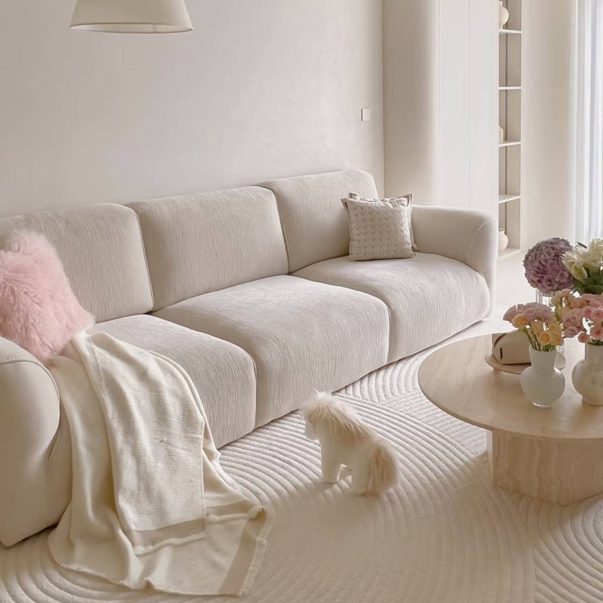 Close-up of beige fabric sofa with flowers on the coffee table