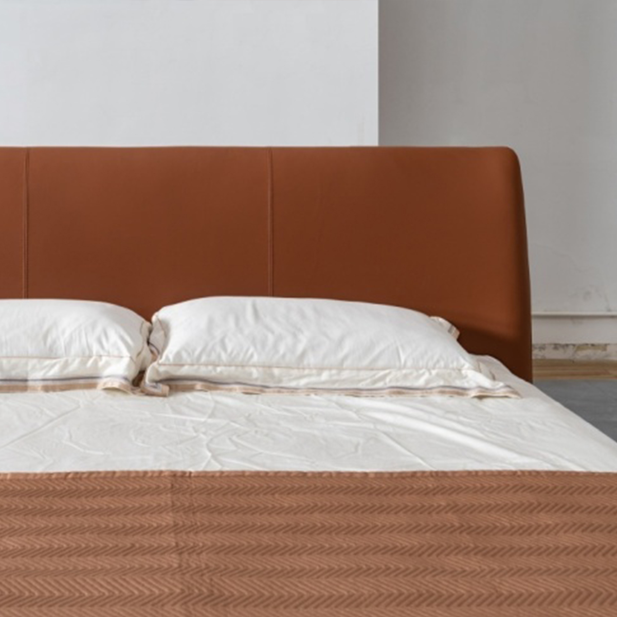 Close-up of the bed headboard and pillows showing leather texture