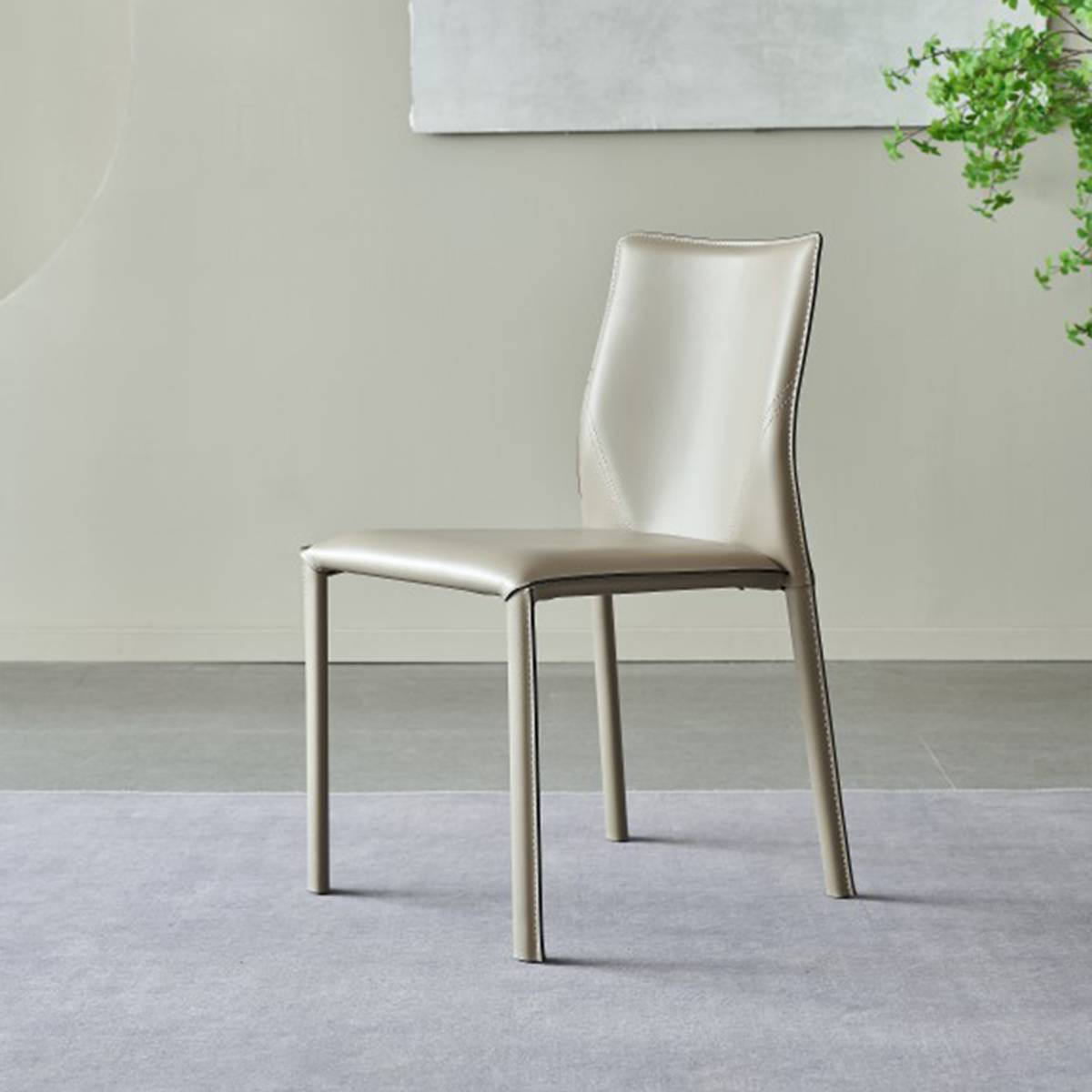 Side view of a grey leather dining chair showing the curved backrest