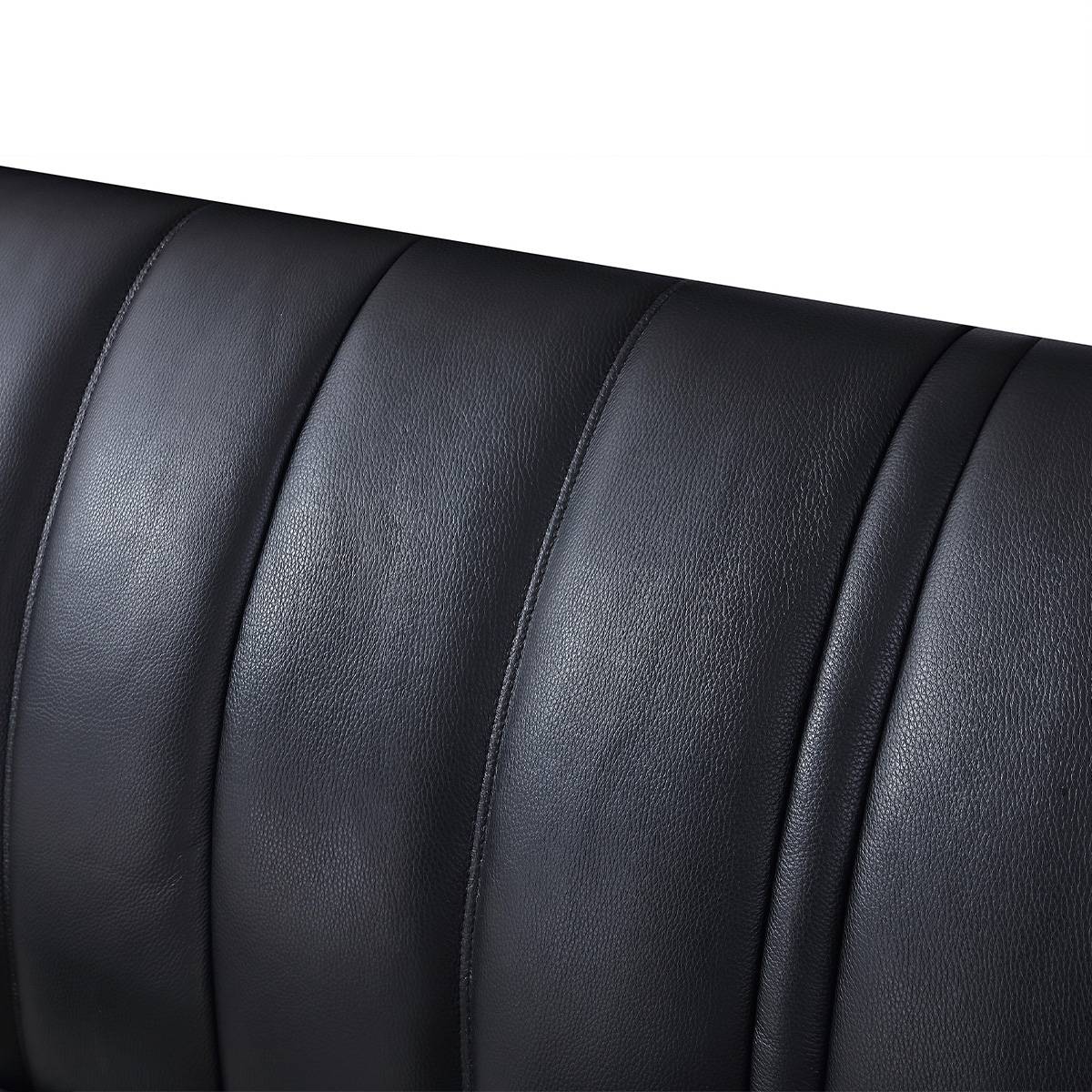 Close-up detail of the black leather headboard with vertical stitching
