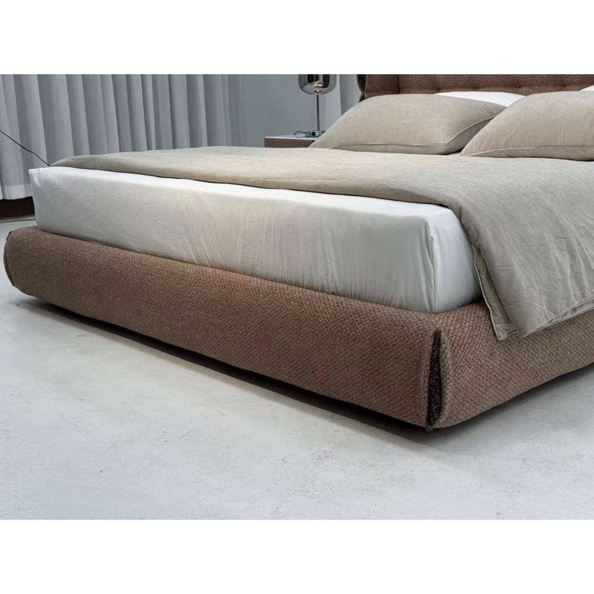 Side view of the upholstered bed frame showing the low-profile base and mattress setup.