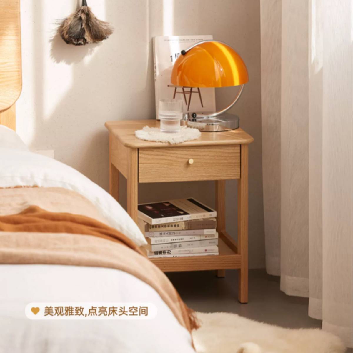 Bedside table in a bedroom setting with an orange lamp and books.