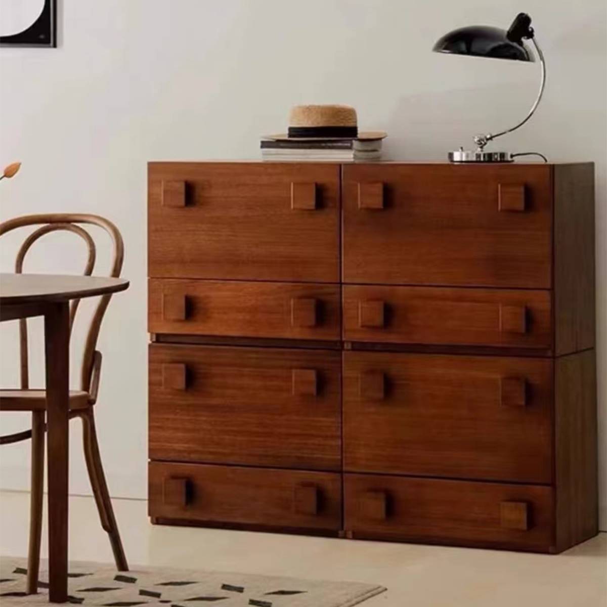 Mid-century modern wooden sideboard with square handles placed next to a dining table