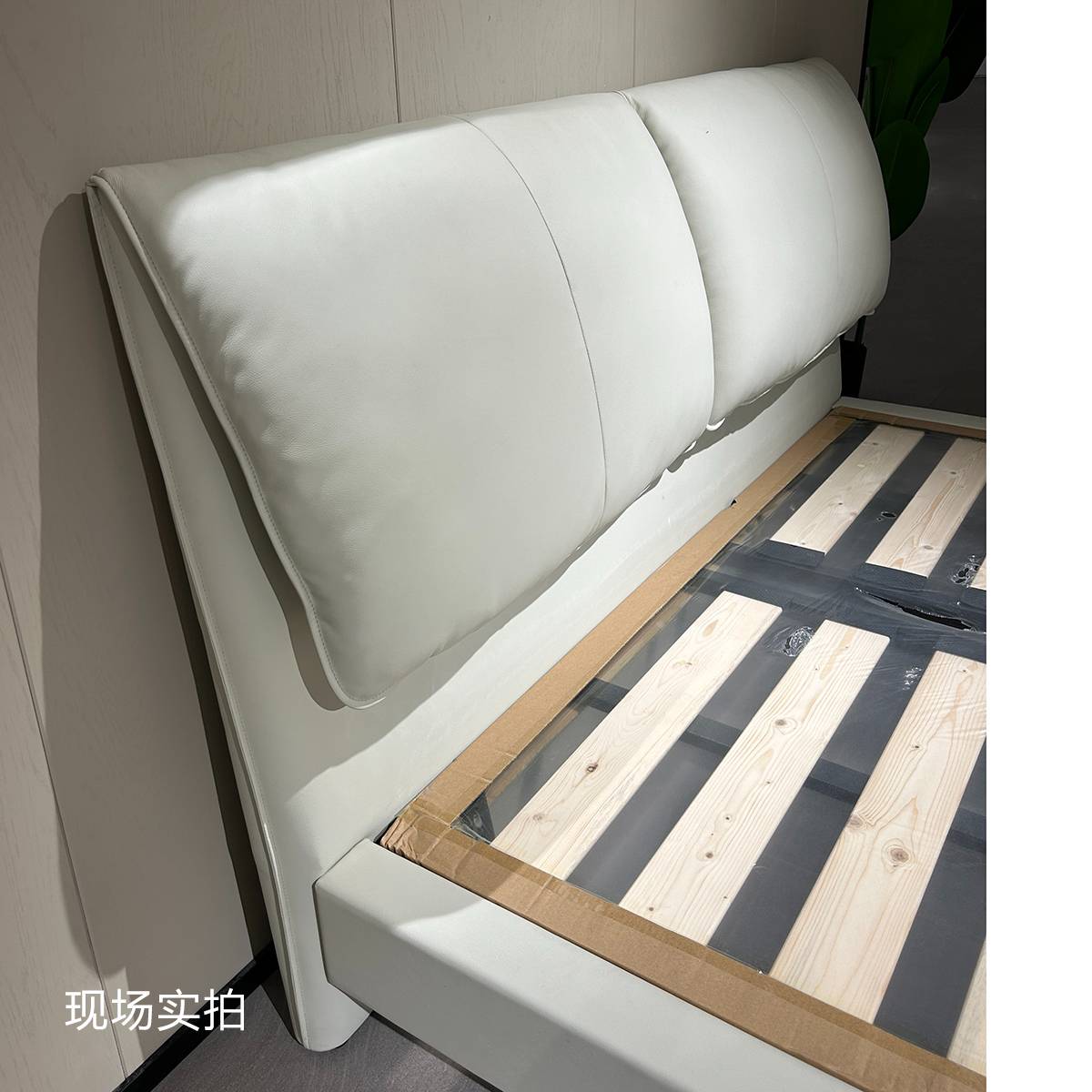 Close-up view of the white leather headboard and wooden slat base of the A19 bed frame