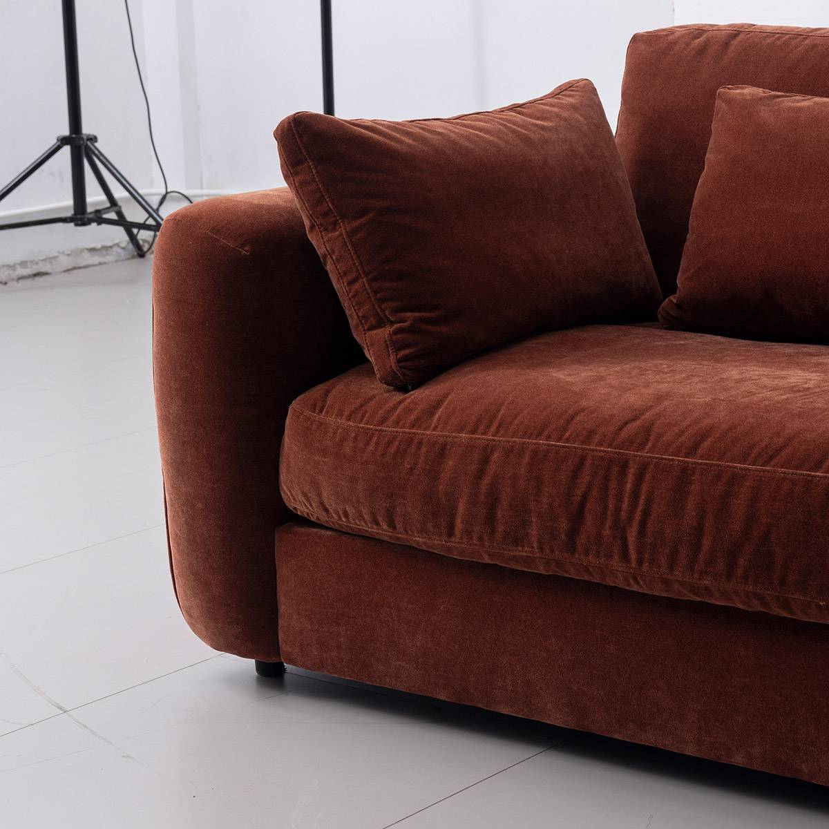 Full view of a terracotta velvet sofa in a modern living room setting