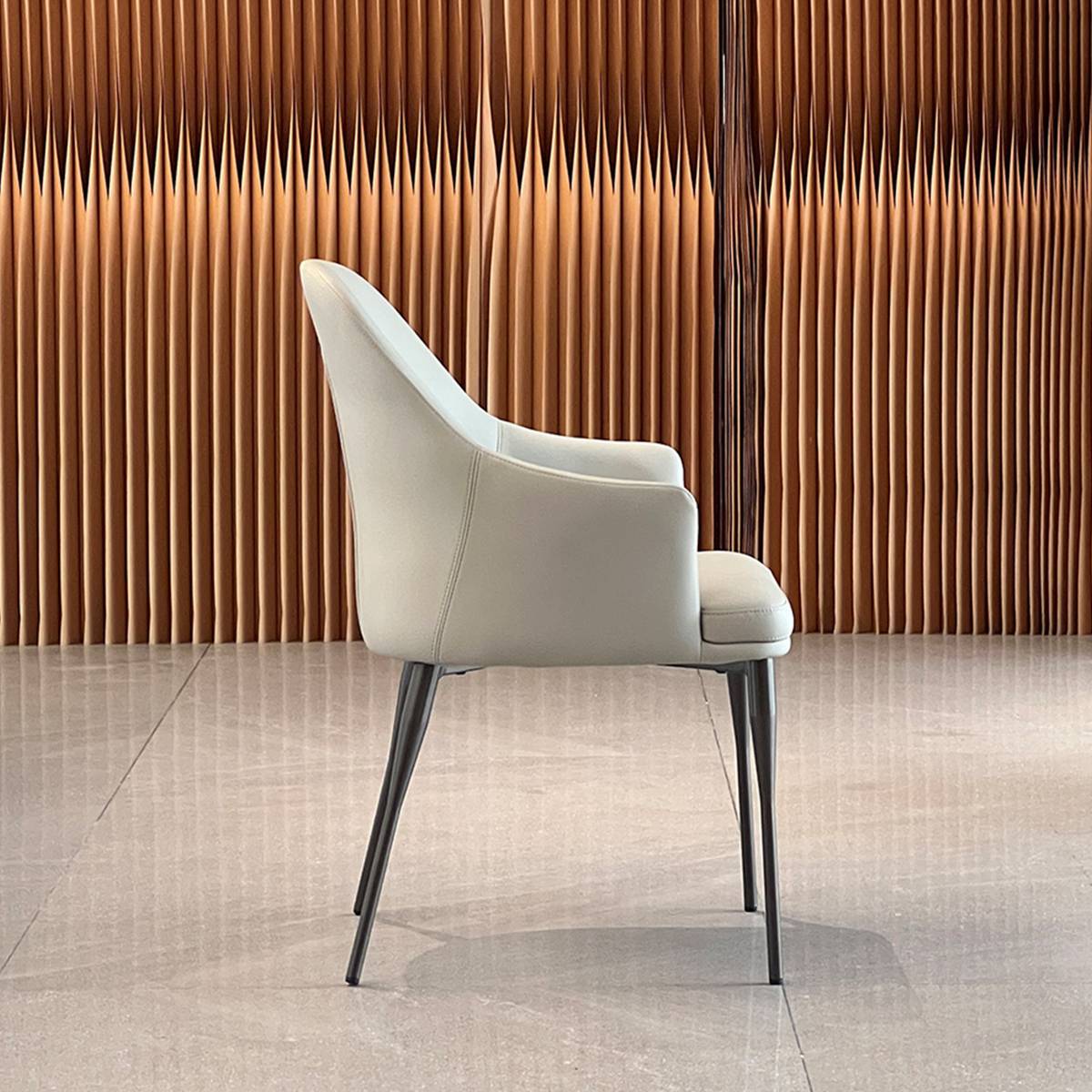 Side profile view of the beige dining chair showing the curved backrest and tapered legs.