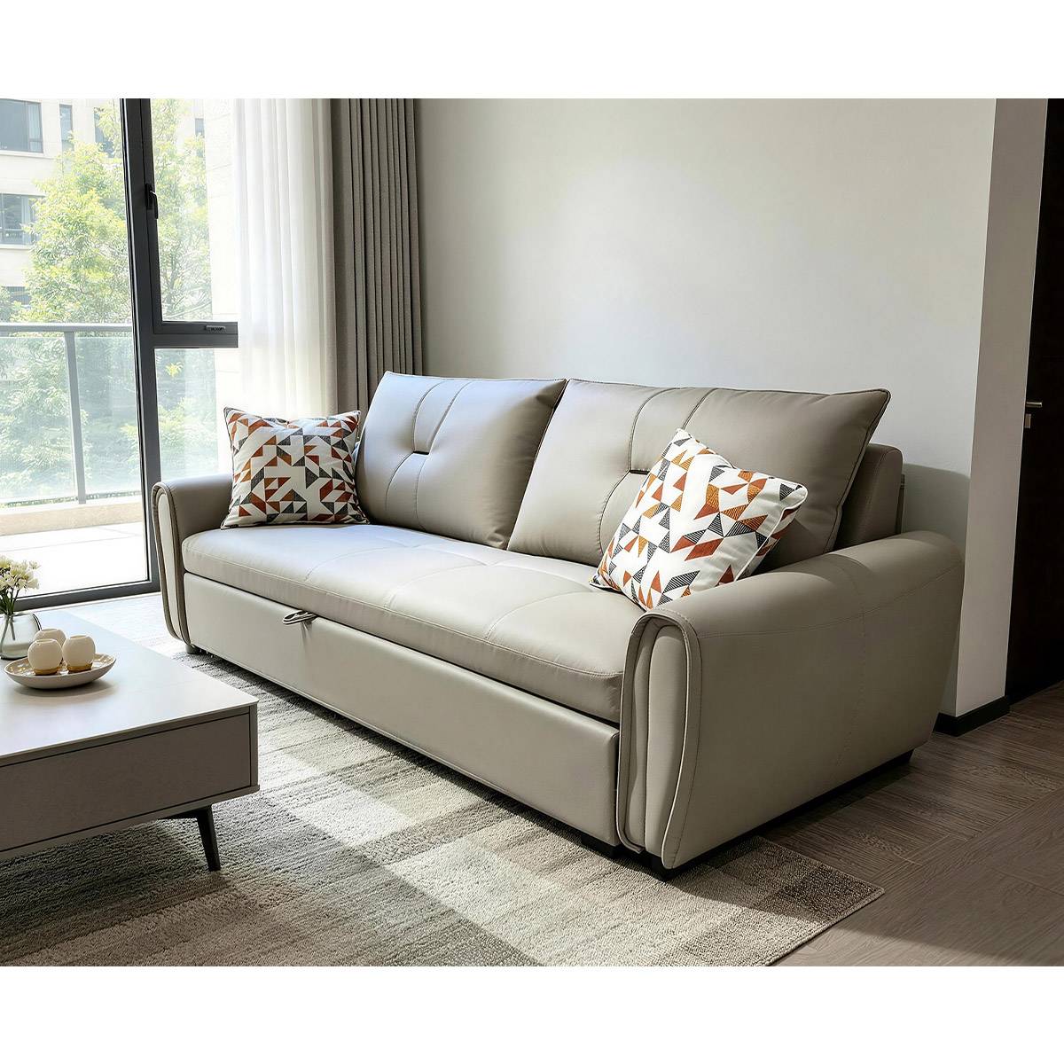 Side view of the beige sofa bed showing the pull-out mechanism handle and geometric patterned pillows