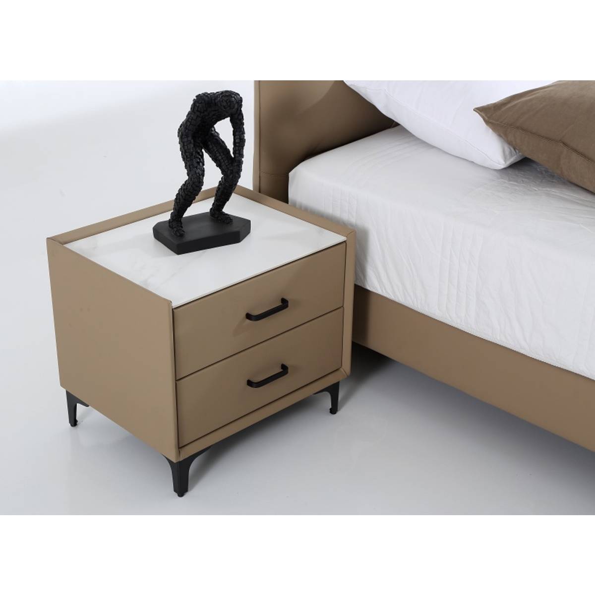 Side view of the beige leather bed frame next to a matching bedside table with a marble top