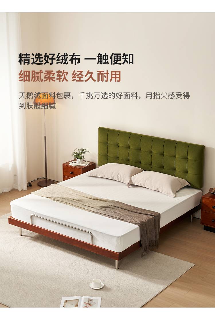 Full view of the bed in a bedroom setting with green velvet headboard