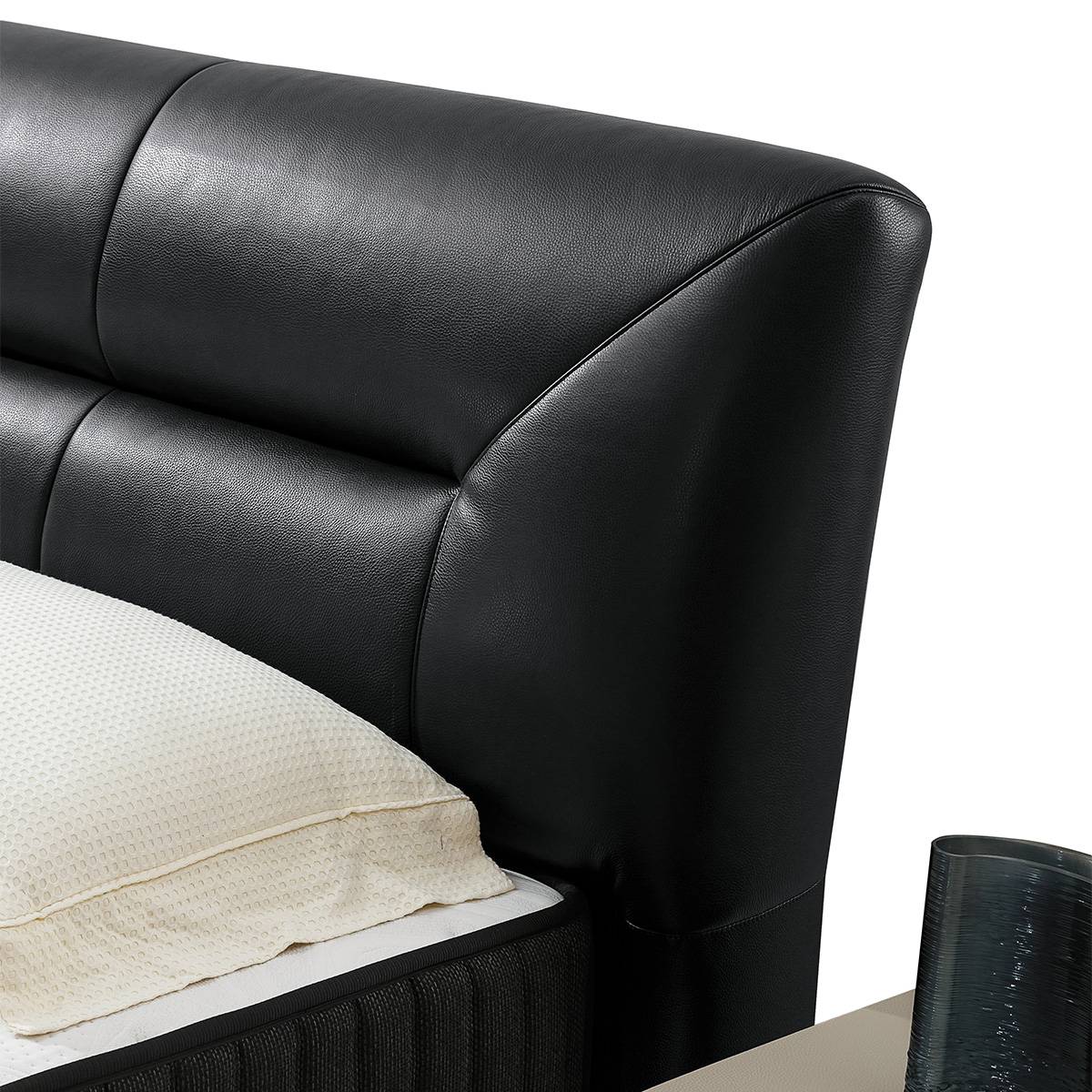 Close-up detail of the black leather headboard texture and stitching