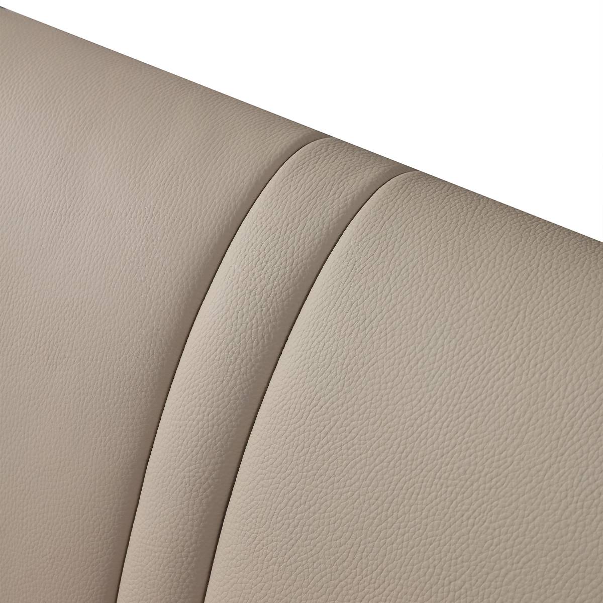 Close-up detail of the beige top-grain leather texture on the bed headboard