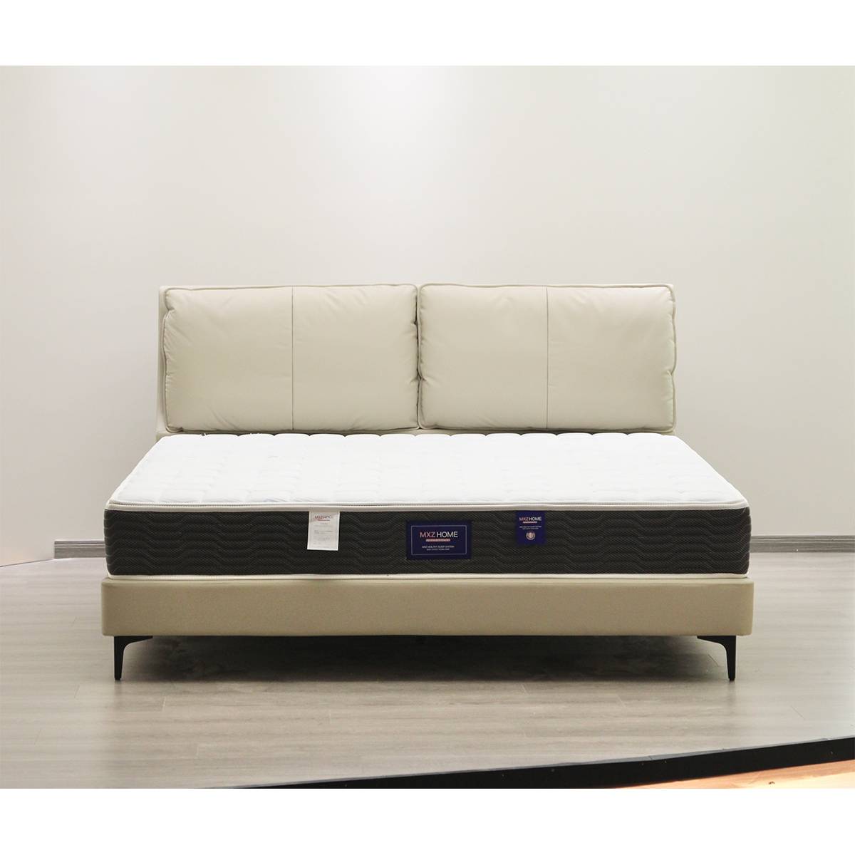 Front view of beige upholstered bed with mattress