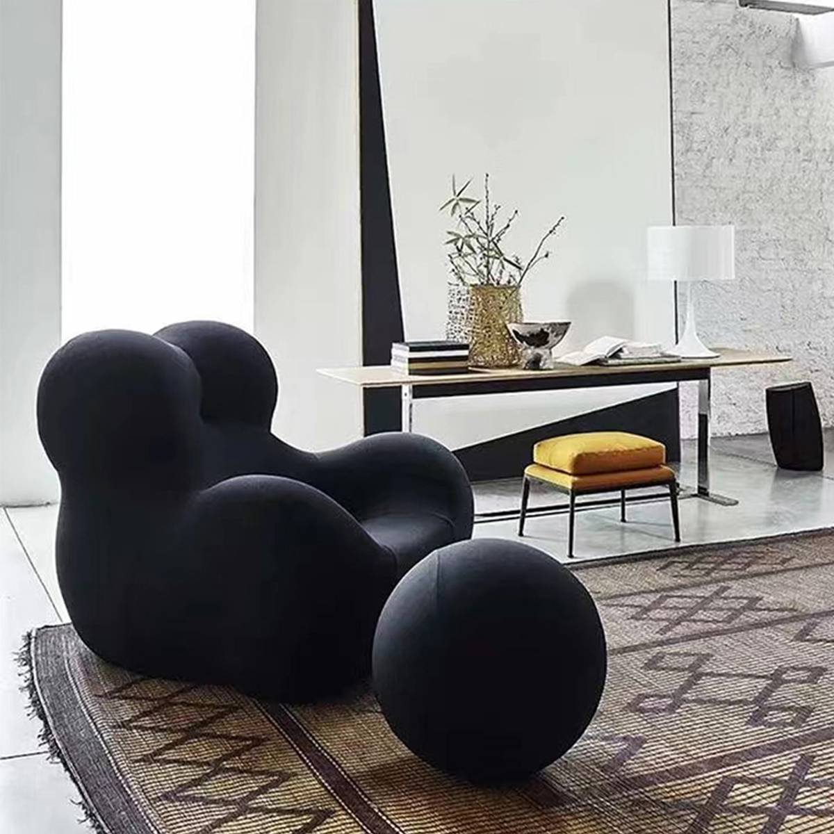 Solid black lounge chair with matching ottoman on a patterned rug