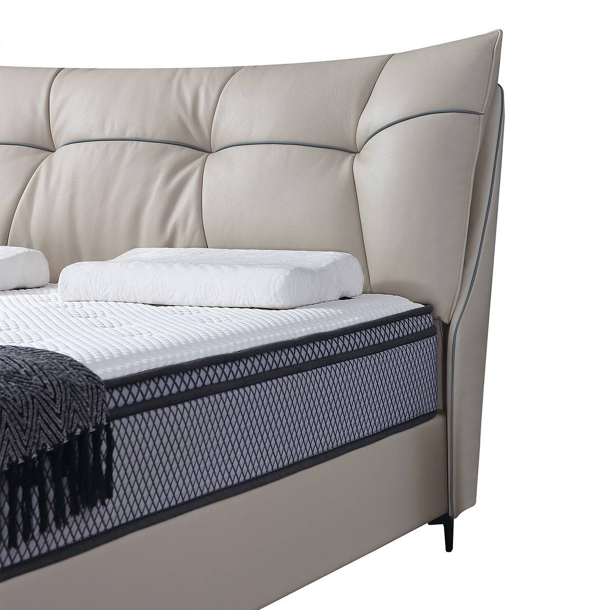 Close-up detail of the tufted leather headboard and mattress edge