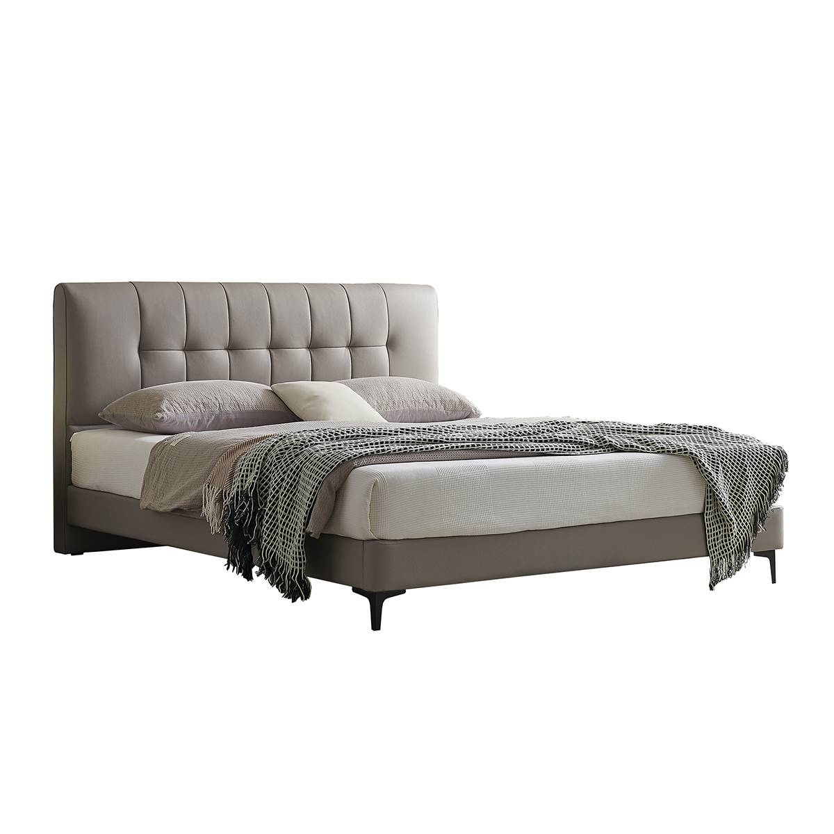 Side view of a grey tufted leather bed with wooden legs