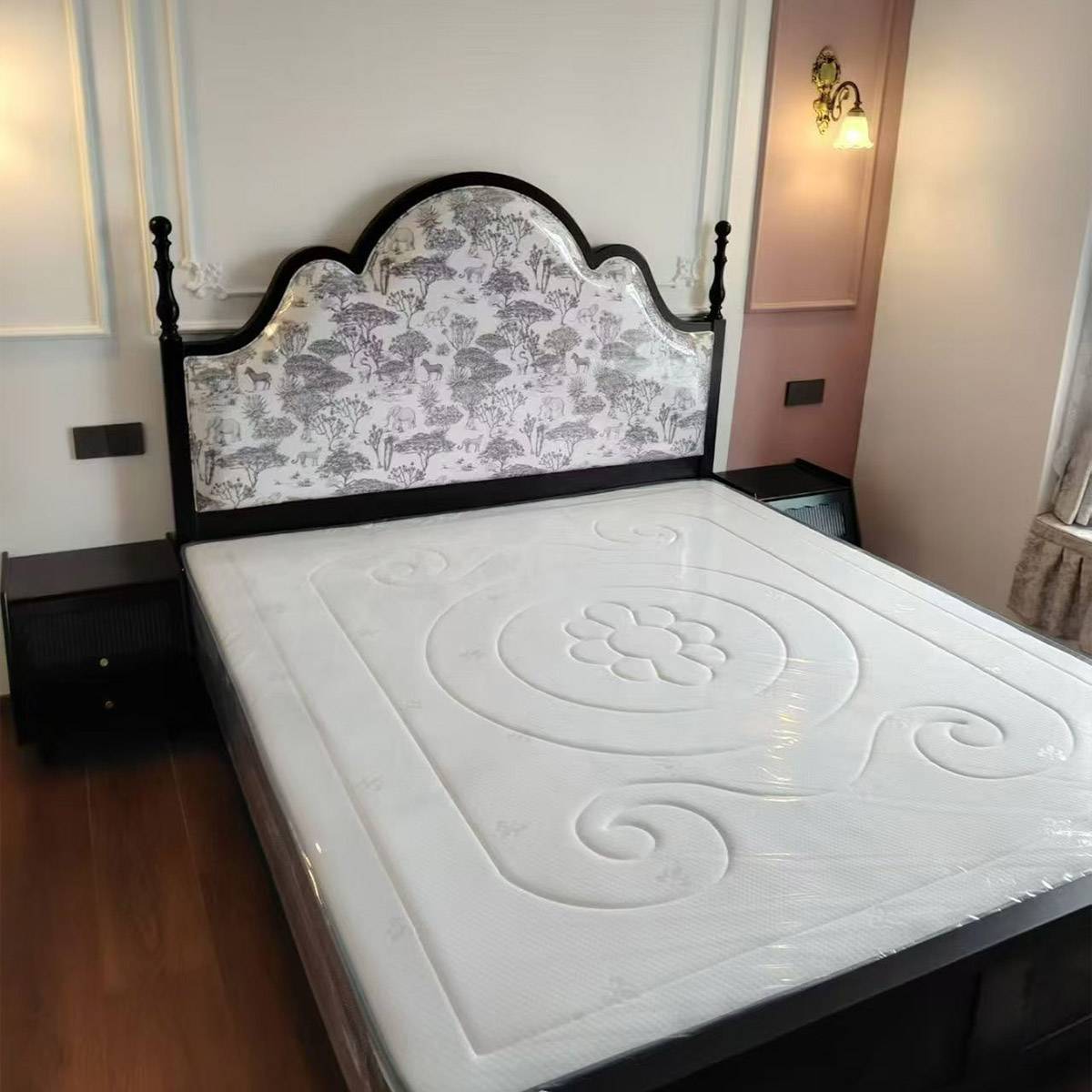Close-up of the bed frame and mattress showing the floral headboard detail