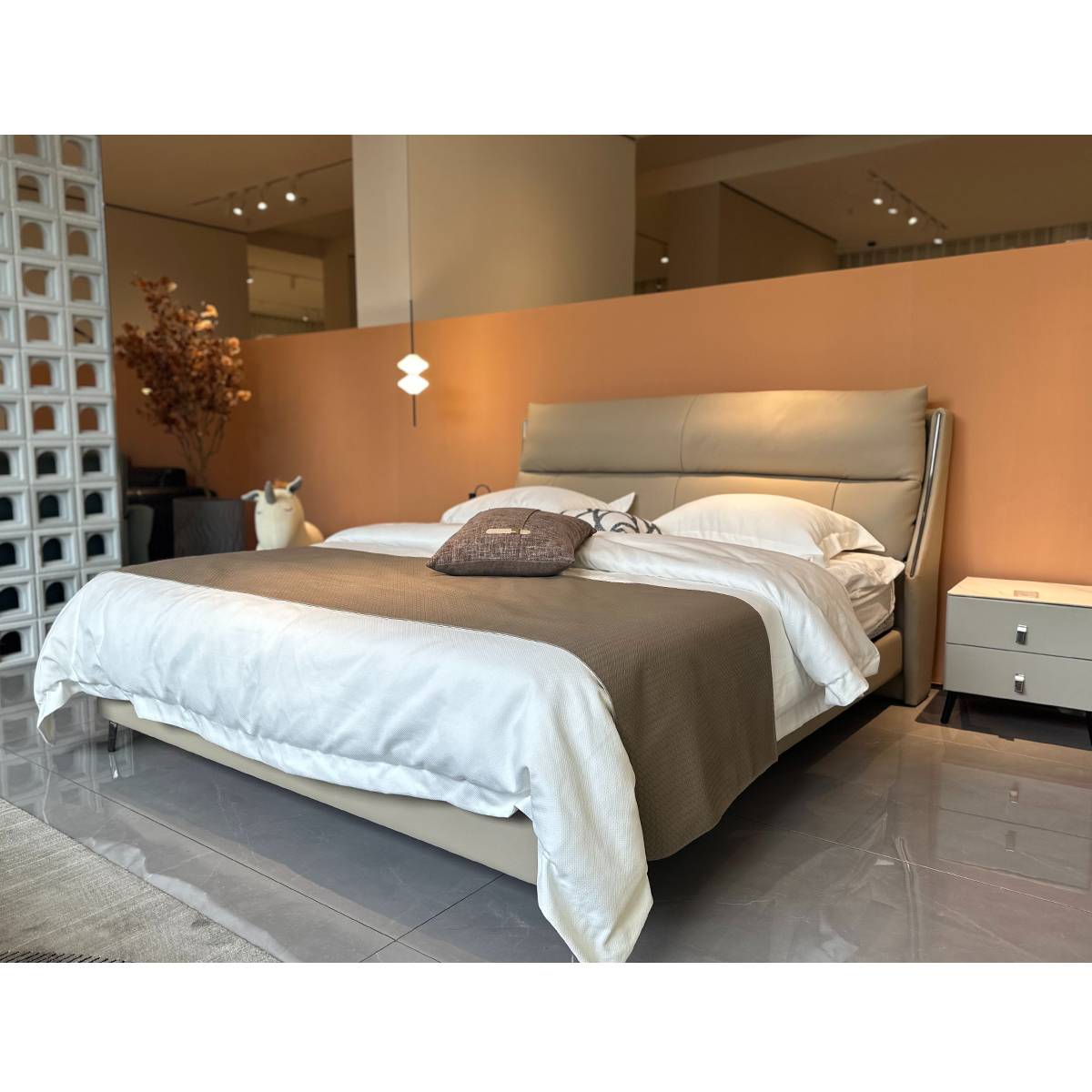 Side view of the modern leather bed with bedside table