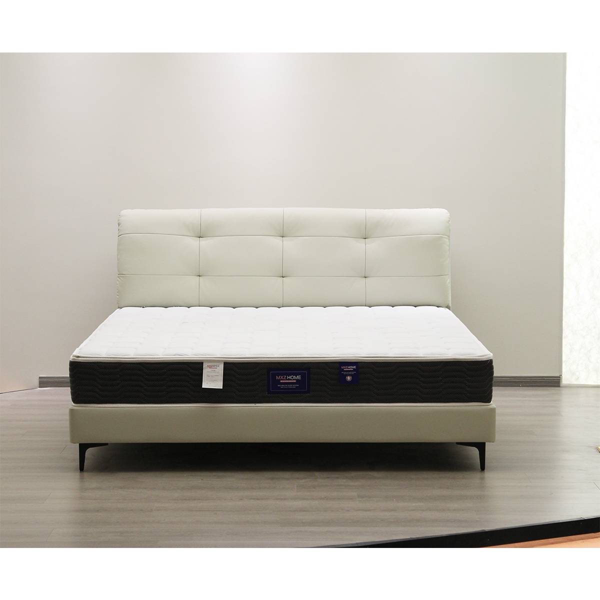 Front view of beige tufted leather bed frame with mattress