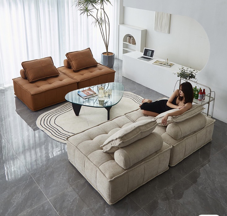 Brown modular sofa in a living room with a textured rug and wooden side table